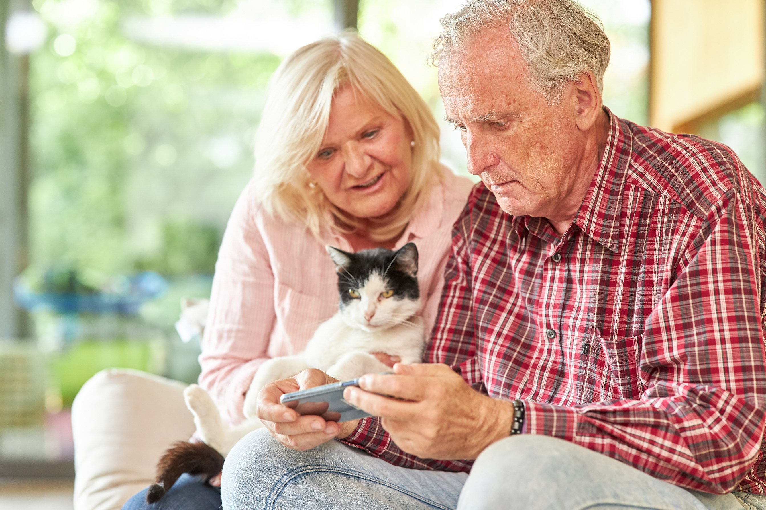 Elderly Couple with Cat and Smartphone